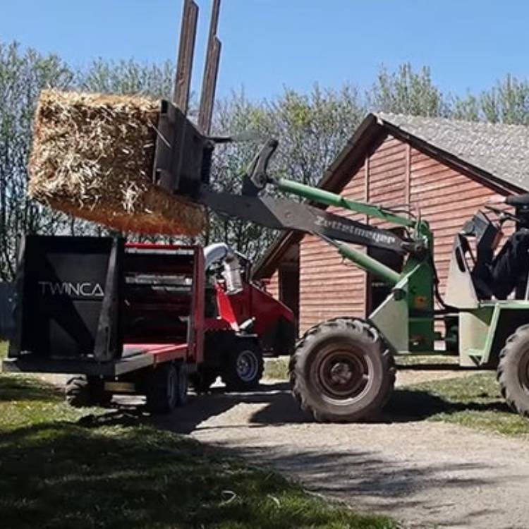 Hálmur settur á hálmdreifara fyrir minkabú