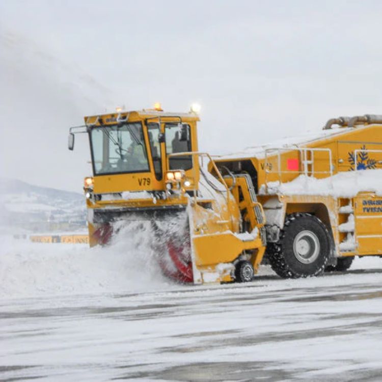 Öflugur snjóblásari að hreynsa snjó af flugbraut